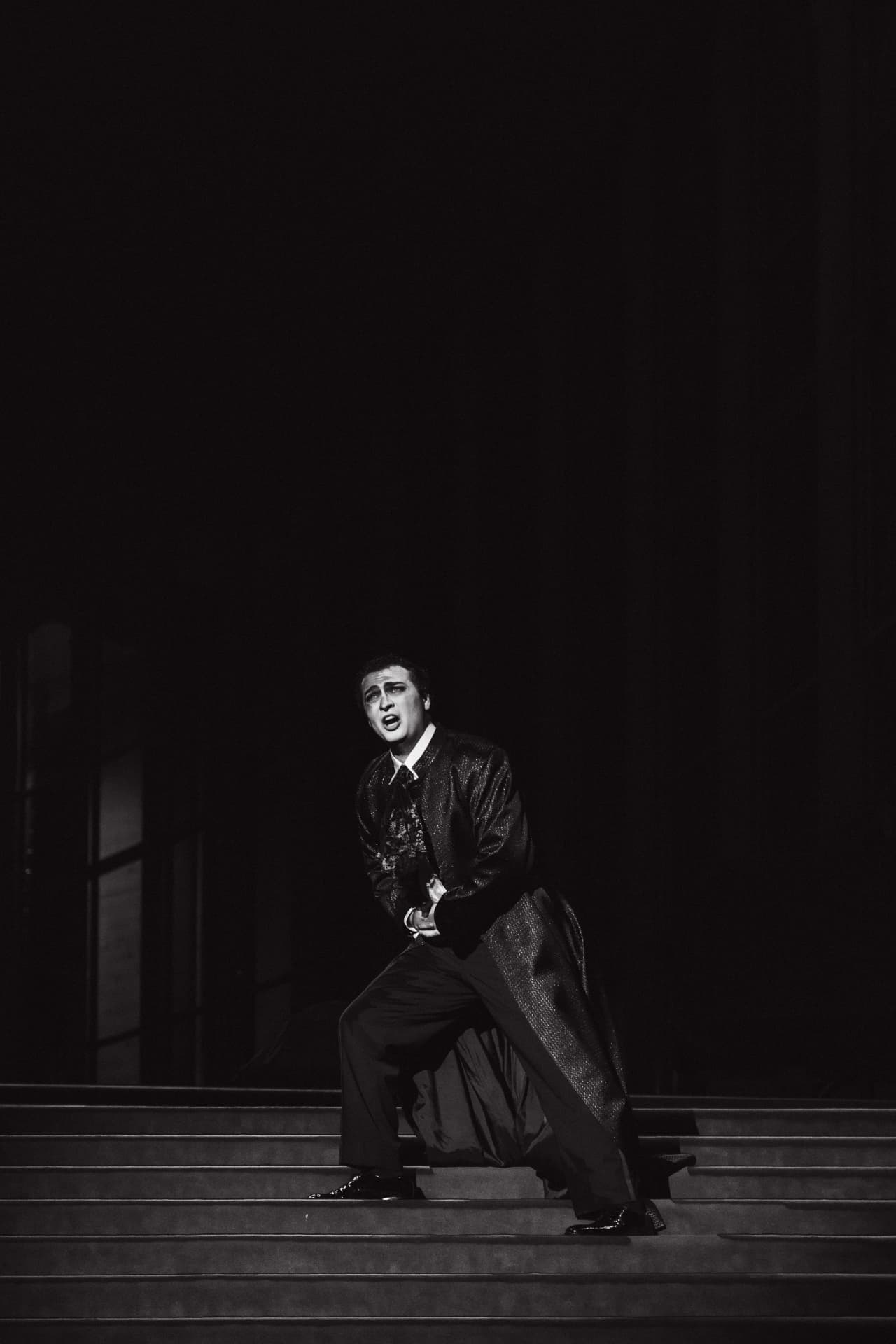 Performer singing on a grand staircase