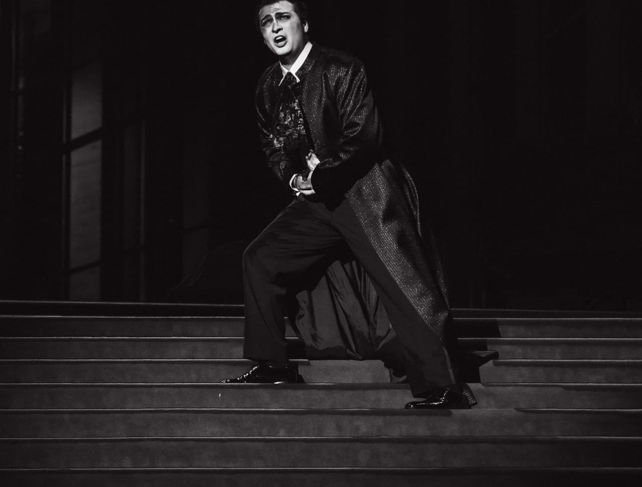 Performer singing on a grand staircase